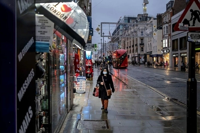 Người dân London đeo khẩu trang, đi lại trên đường phố vắng vẻ trong ngày đầu tiên thành phố áp đặt lệnh hạn chế cấp độ 3. Ảnh:NY Times