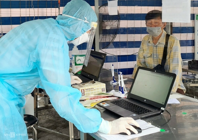 Nhân viên Bệnh viện Quân y 175 hỗ trợ người đến khám khai báo y tế điện tử. Ảnh: Lê Phương.