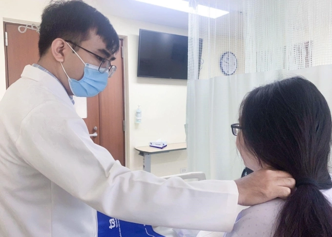 Bác sĩ Lê Thanh Tuấn kiểm tra sức khỏe người bệnh sau khi mổ bướu giáp. Ảnh: Nguyễn Trăm