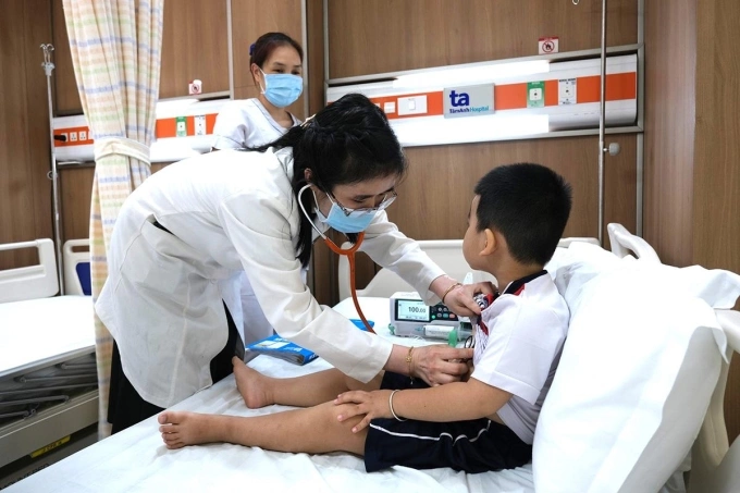 Bác sĩ Ngọc kiểm tra cho bệnh nhi trước xuất viện. Ảnh: Tuệ Diễm
