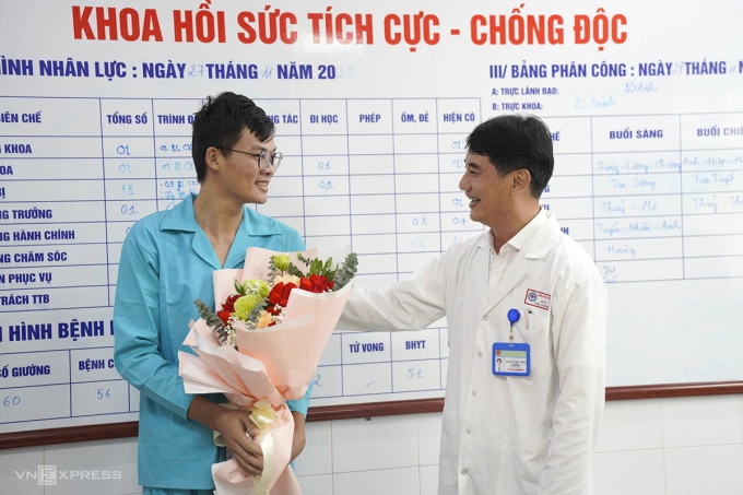TS.BS Lê Đức Nhân tặng hoa chúc mừng bệnh nhân được xuất viện, sáng 27/11. Ảnh: Nguyễn Đông