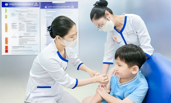 Bé trai được phụ huynh đưa đi tiêm vaccine phòng viêm não Nhật Bản tại Trung tâm tiêm chủng VNVC. Ảnh: Hoàng Dương