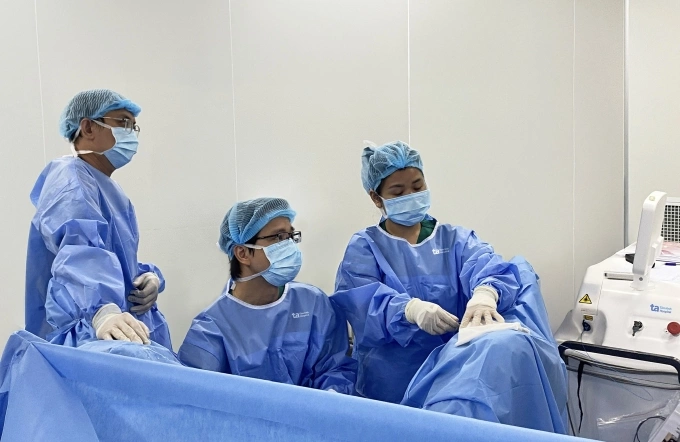 BS.CKI Phan Trường Nam (ngồi) cùng êkip thực hiện phẫu thuật nội soi cắt đốt laser tuyến tiền liệt qua ngả niệu đạo điều trị phì đại tuyến tiền liệt cho ông Sigurd. Ảnh: Bệnh viện Đa khoa Tâm Anh