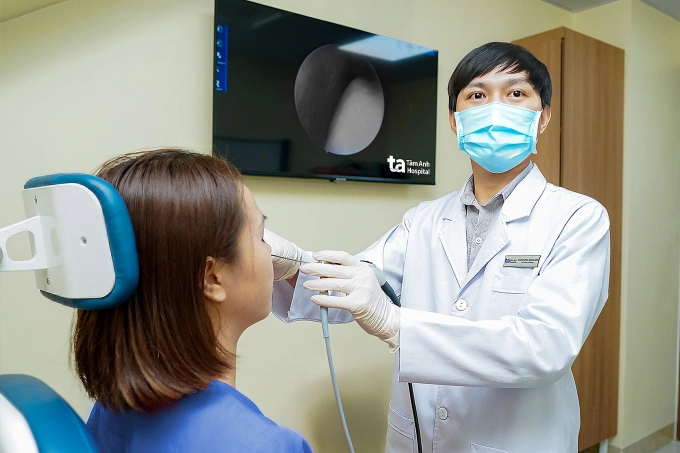 Bác sĩ Minh nội soi mũi cho chị Thương. Ảnh: Bệnh viện Đa khoa Tâm Anh