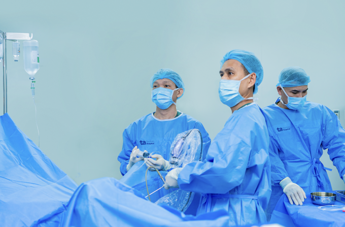 Bác sĩ Cương (trái) nội soi tán sỏi ngược dòng bằng ống mềm cho ông Noah. Ảnh: Bệnh viện Đa khoa Tâm Anh TP HCM