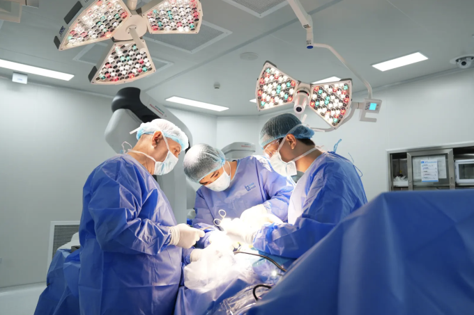 Bác sĩ thực hiện phẫu thuật dưới nguồn ánh sáng mạnh trong phòng mổ. Ảnh: Bệnh viện Tâm Anh