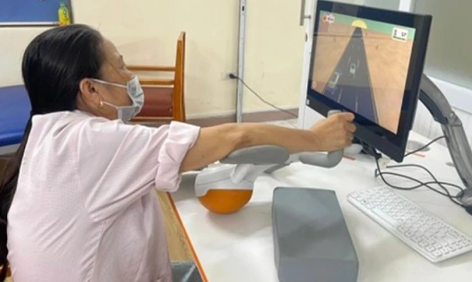 Bệnh nhân đột quỵ vận động theo mô phỏng thực tế ảo tại Bệnh viện Bạch Mai. Ảnh: Bệnh viện cung cấp