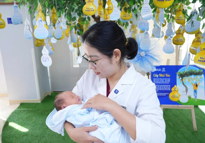 Bác sĩ IVF Tâm Anh thăm mẹ con chị Hồng trước khi xuất viện. Ảnh: Trà My