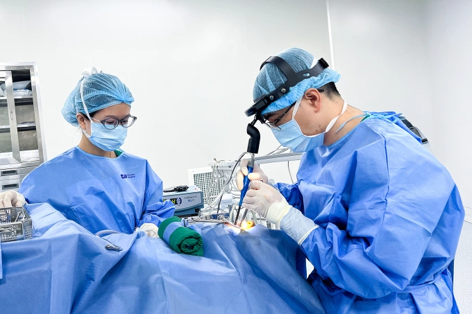 Bác sĩ Hữu (phải) đang phẫu thuật cắt amidan cho một bệnh nhi. Ảnh: Bệnh viện Đa khoa Tâm Anh
