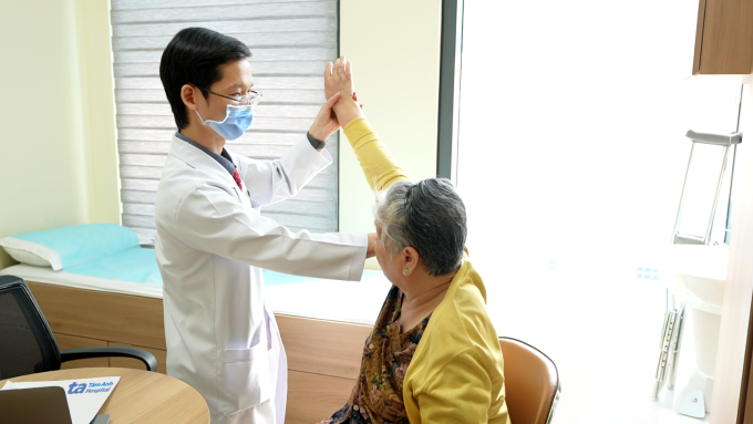 Bác sĩ Dương kiểm tra tình trạng vận động khớp vai của bà Xừ trong lần tái khám. Ảnh: Bệnh viện Đa khoa Tâm Anh