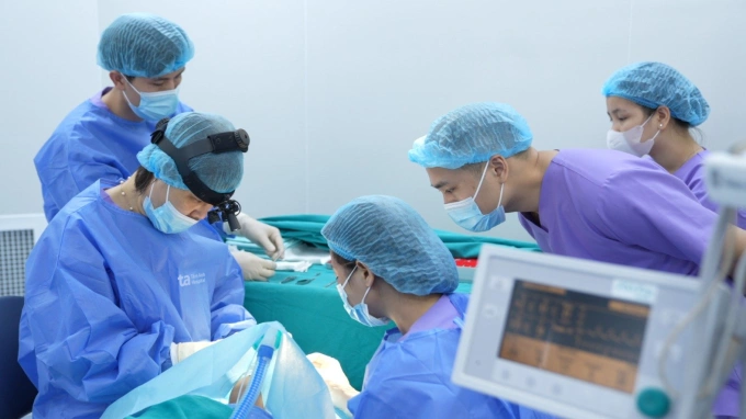 PGS Hiền (bên trái) thực hiện phẫu thuật lác cho trẻ. Ảnh: Bệnh viện Đa khoa Tâm Anh