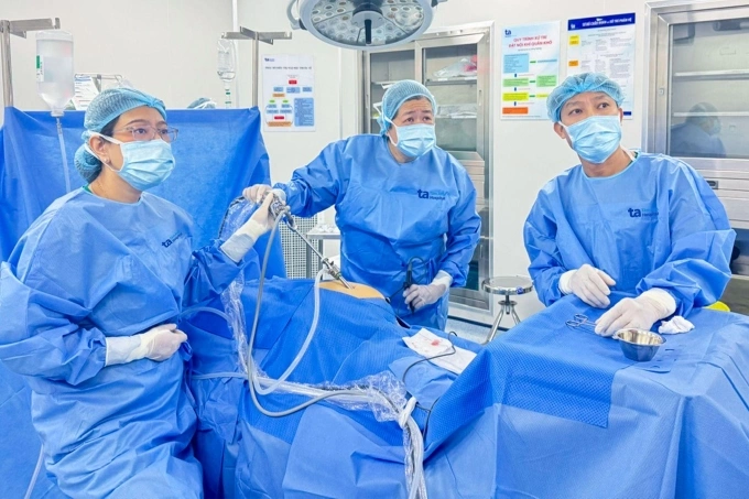 Bác sĩ Trà (trái) và bác sĩ Mỹ Nhi (giữa) nội soi lấy mẫu sinh thiết cho chị Thùy. Ảnh: Tuệ Diễm