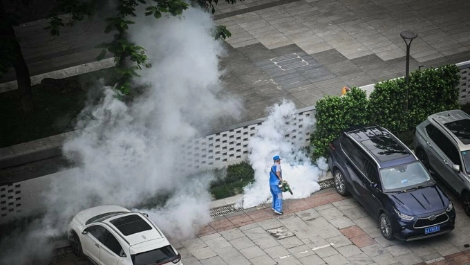 Nhân viên y tế phun thuốc diệt muỗi tại sân để xe của một tòa nhà ở Trung Quốc. Ảnh: VCG