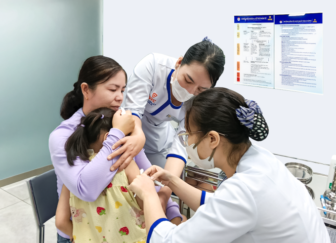 Chị Hồng đưa con gái đi tiêm vaccine sốt xuất huyết tại Hệ thống Tiêm chủng VNVC. Ảnh: Hoàng Dương