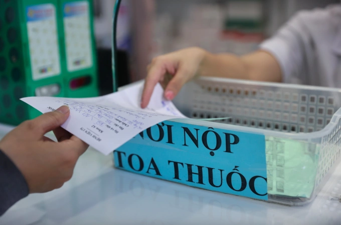 Nhân viên y tế tại nhà thuốc phát thuốc cho bệnh nhân. Ảnh:Quỳnh Trần