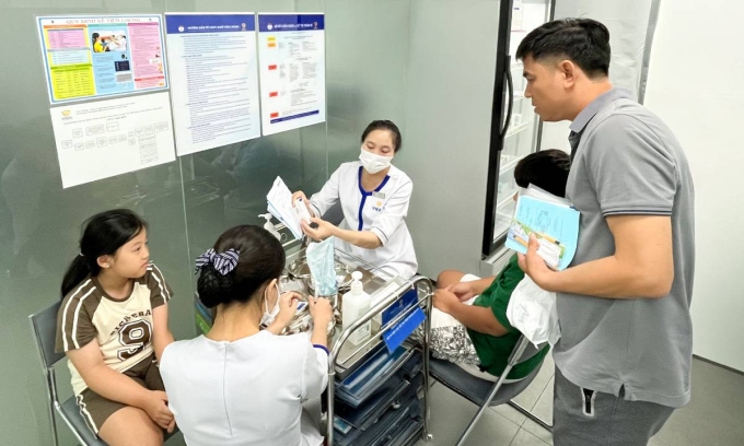 Chồng và hai con chị Minh Quyên tiêm vaccine sốt xuất huyết tại Trung tâm Tiêm chủng VNVC Đặng Văn Bi, phường Thủ Đức, TP HCM. Ảnh: Diệu Thuần