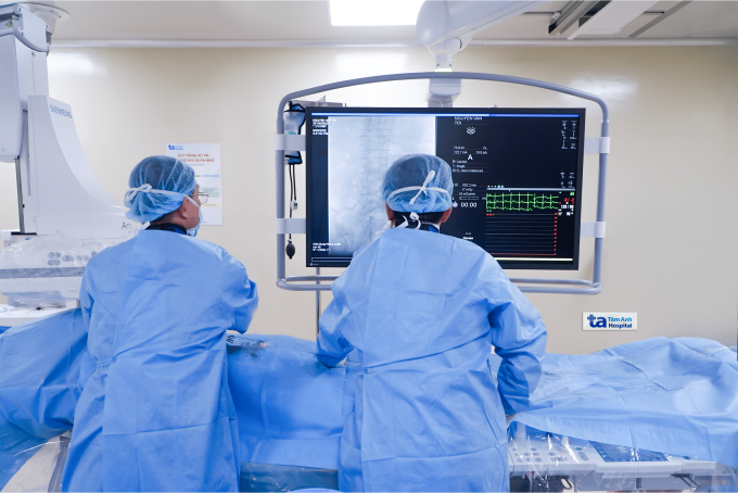 Bác sĩ Dũng (trái) cùng ê kíp đặt stent graft động mạch chậu cho bệnh nhân. Ảnh: Hạ Vũ
