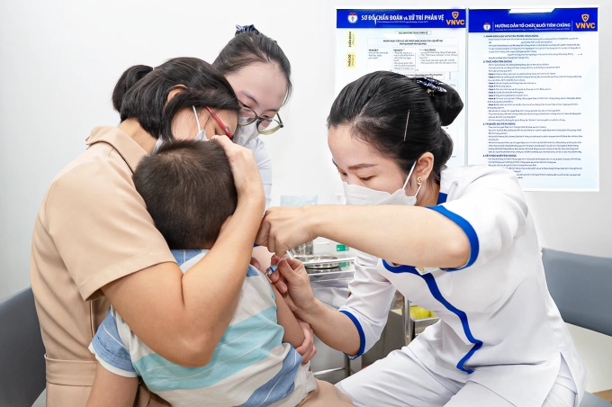 Chị Vũ Thị Thanh, xã Vĩnh Lộc, TP HCM đưa con trai 4 tuổi tiêm vaccine não mô cầu tại VNVC sáng 15/8. Ảnh: Mộc Thảo