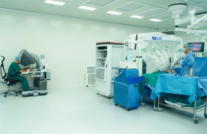 PGS Chuyên (trái) điều khiển robot Da Vinci Xi cắt khối u nằm ở giữa thận phải cho chị Mai. Ảnh: Bệnh viện Đa khoa Tâm Anh