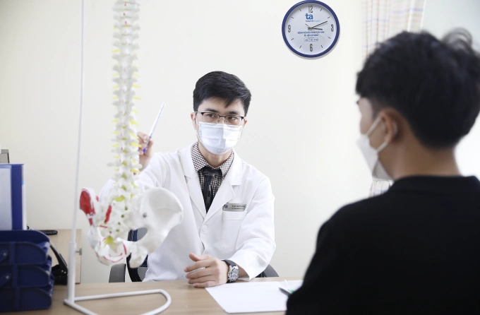 Bác sĩ Thắng giải thích tình trạng chức năng cột sống cho người bệnh. Ảnh: Bệnh viện Đa khoa Tâm Anh