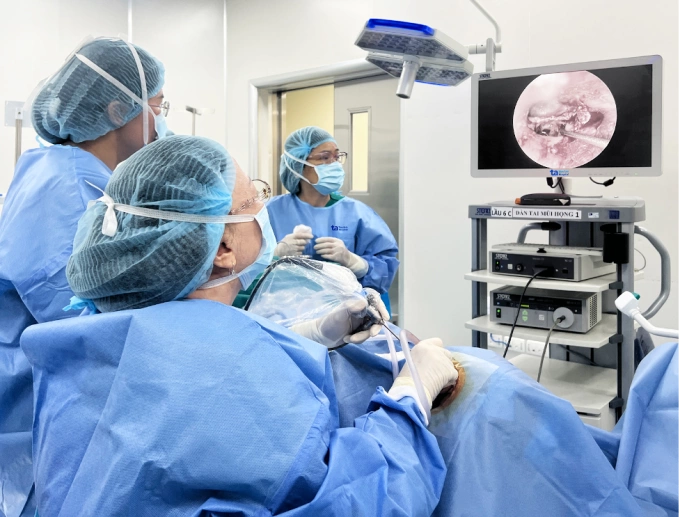 Giáo sư Thủy (ngồi) phẫu thuật thay xương bàn đạp qua nội soi cho ông Thắng. Ảnh: Bệnh viện Đa khoa Tâm Anh