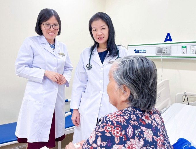Bác sĩ Bình (trái) và bác sĩ Kiều hỏi thăm tình trạng cụ bà trước lúc xuất viện. Ảnh: Hạ Vũ