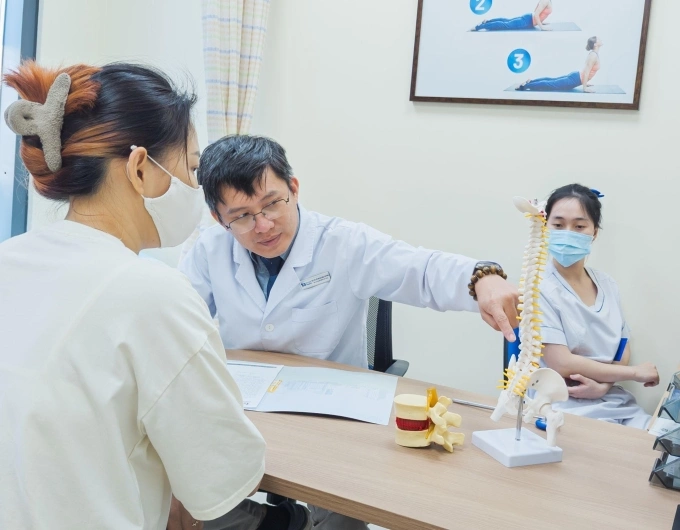 Bác sĩ giải thích cho người bệnh các tư thế ảnh hưởng đến cột sống. Ảnh: Bệnh viện Đa khoa Tâm Anh