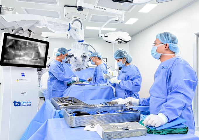 Bác sĩ phẫu thuật lấy u trong ống sống cho anh Nguyên với sự hỗ trợ của kính vi phẫu AI. Ảnh: Bệnh viện Đa khoa Tâm Anh