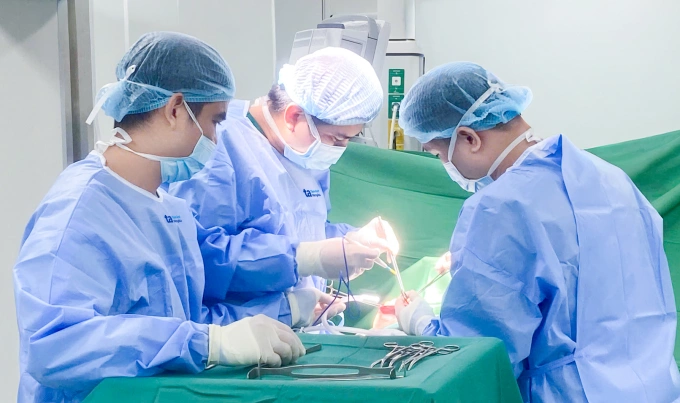 Bác sĩ Mạnh (giữa) và êkíp phẫu thuật bóc tách khối u vú phải cho người bệnh. Ảnh: Minh Tâm