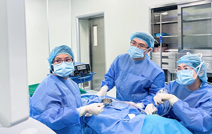 Bác sĩ Phương (ngồi) đang vá nhĩ qua nội soi cho bé Thơ. Ảnh: Bệnh viện Đa khoa Tâm Anh