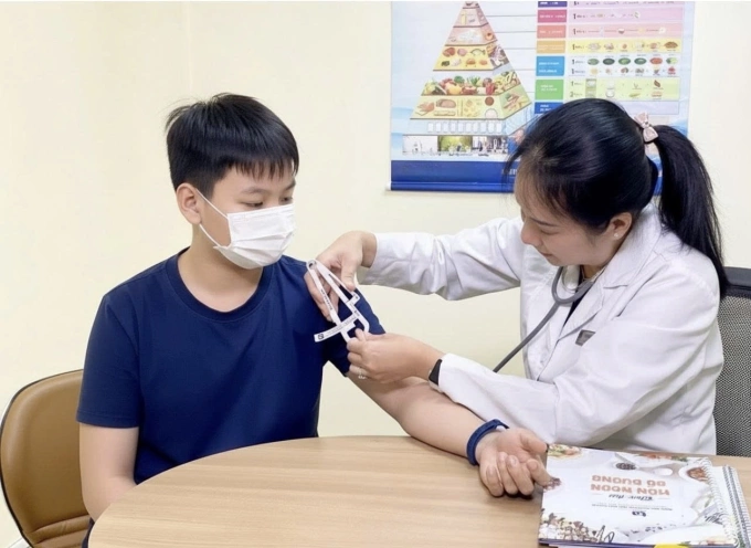 Bác sĩ Yến Thủy đo chỉ số bề dày lớp mỡ dưới da, đánh giá tình trạng dinh dưỡng và tư vấn chế độ ăn cho trẻ. Ảnh: Bệnh viện Đa khoa Tâm Anh
