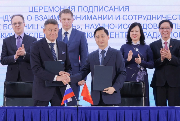 Ông Kaprin Andrey Dmitrievich - Tổng giám đốc Trung tâm Y học Quốc gia về Xạ trị, Viện Hertsen Liên bang Nga (trái) trao đổi văn kiện hợp tác với ông Ngô Chí Dũng, Chủ tịch HĐQT Hệ thống BVĐK Tâm Anh và Viện Nghiên cứu Tâm Anh (TAMRI) chiều 12/9, với sự chứng kiến của Bộ trưởng Y tế Liên bang Nga Mikhail Albertovich Murashko và Bộ trưởng Y tế Đào Hồng Lan