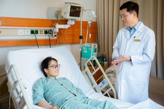 Bác sĩ Lê Văn Thành trò chuyện với bệnh nhân Dương Thị Mến sau ca ghép gan thành công. Ảnh: Vinmec