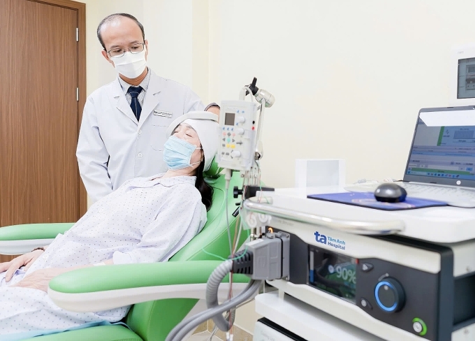 Bác sĩ Tuấn Anh thực hiện kích thích từ trường xuyên sọ cho người bệnh. Ảnh: Bệnh viện Đa khoa Tâm Anh