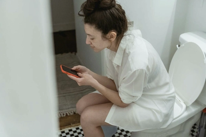 Một người đang sử dụng điện thoại khi đi vệ sinh. Ảnh: Pexel