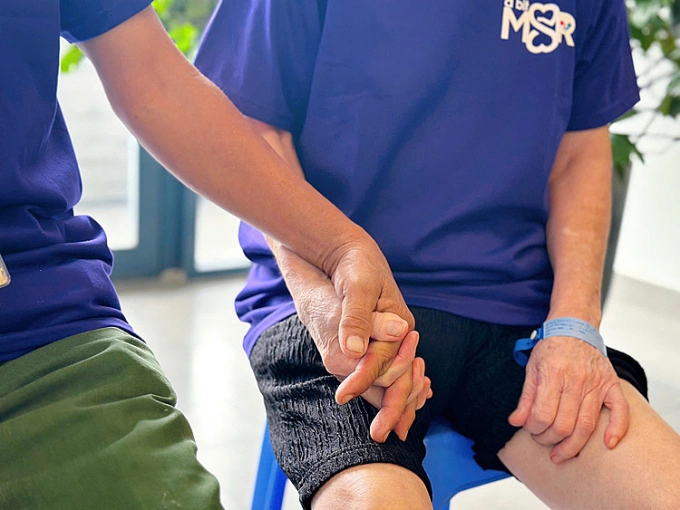 Ông Nhan lúc nào cũng nắm chặt tay người vợ không rời. Ảnh: Thúy Quỳnh