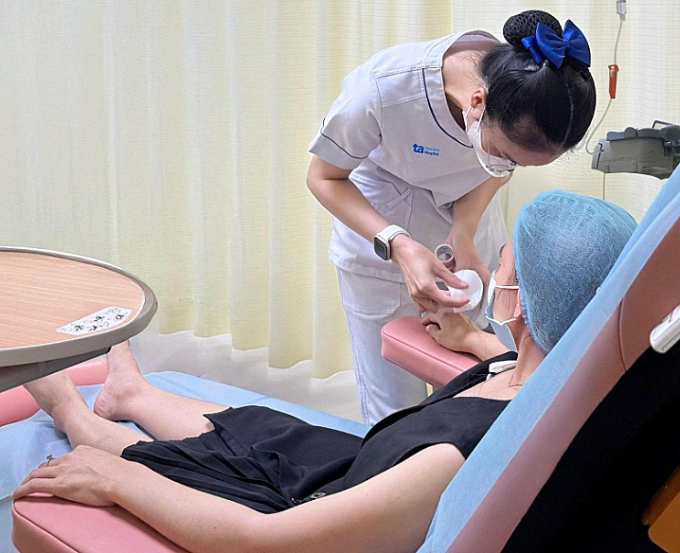 Điều dưỡng truyền thuốc cho chị Hằng trên ghế chuyên dụng dễ dàng điều chỉnh tư thế, êm ái. Ảnh: Bệnh viện Đa khoa Tâm Anh
