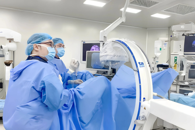 BS.CKI Phan Huỳnh Tiến Đạt (phía trong) thực hiện tán sỏi nội soi ngược dòng bằng ống mềm. Ảnh: Bệnh viện Đa khoa Tâm Anh