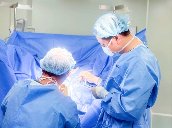 Bác sĩ Biên (phải) đang phẫu thuật cắt trĩ cho chị Thanh. Ảnh: Bệnh viện Đa khoa Tâm Anh