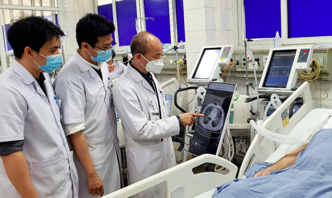 Các bác sĩ Bệnh viện Bạch Mai kiểm tra phim chụp của bệnh nhân hiển thị trên bệnh án điện tử ngay tại giường bệnh. Ảnh:Nguyên Hà