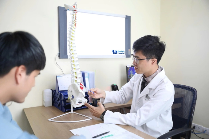 Bác sĩ Thắng giải thích tình trạng sức khỏe cột sống cho người bệnh. Ảnh: Bệnh viện Đa khoa Tâm Anh