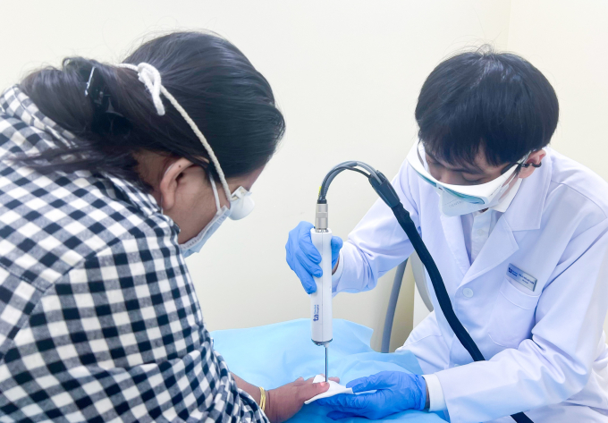 Bác sĩ sử dụng laser Nd:YAG xung dài điều trị nấm móng cho chị Phương. Ảnh: Bệnh viện Đa khoa Tâm Anh
