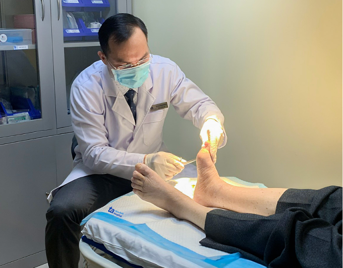 Bác sĩ Duy chăm sóc vết thương của ông Khái. Ảnh: Bệnh viện Đa khoa Tâm Anh