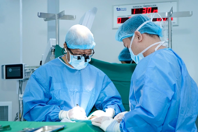 Bác sĩ Trông (trái) và bác sĩ Hiếu đang phẫu thuật cho bệnh nhân Hoàng. Ảnh: Bệnh viện cung cấp