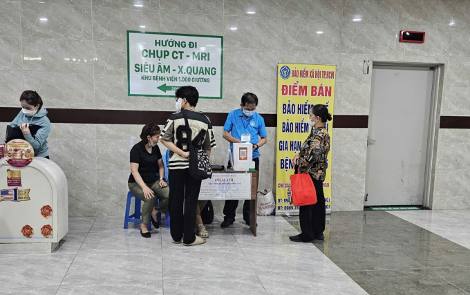 Người dân giao dịch ở đại lý mua bán bảo hiểm đặt tại Bệnh viện Quân y 175, chiều 10/10. Ảnh: Lê Phương