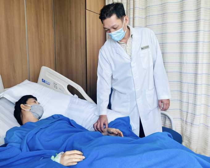 Bác sĩ Cương kiểm tra sức khỏe chị An sau ca mổ cắt u thận phải. Ảnh: Bệnh viện Đa khoa Tâm Anh