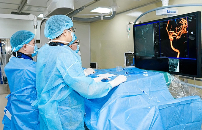 Bác sĩ Hoàn (phải) và êkíp đặt stent thay đổi dòng chảy điều trị túi phình mạch máu cho người bệnh. Ảnh: Bệnh viện Đa khoa Tâm Anh