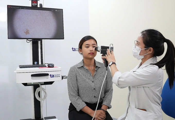 Bác sĩ chuyên khoa Da liễu đang thăm khám cho một khách hàng. Ảnh: Bệnh viện cung cấp