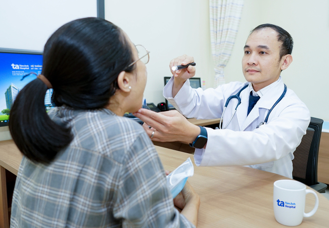 Bác sĩ Minh Thuận đang kiểm tra họng cho người bệnh. Ảnh: Bệnh viện Đa khoa Tâm Anh