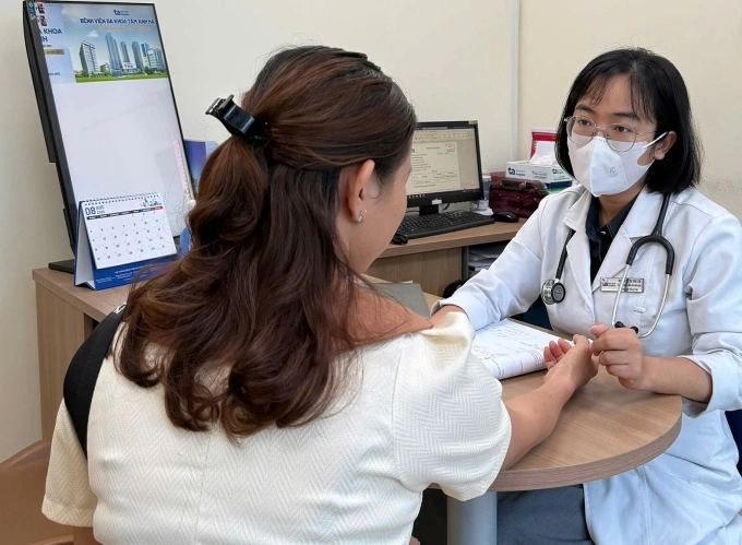 Vì sao phụ nữ sau sinh dễ bị dị ứng? Bác sĩ Tùng Lâm đang khám cho một người bệnh nổi mề đay sau sinh. Ảnh minh họa: Bệnh viện Đa khoa Tâm Anh